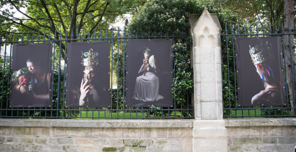 Portraits de femmes prises en charge par la Maison des femmes de Saint-Denis, posant en reines et exposés sur les grilles du jardin de la Basilique Cathédrale.